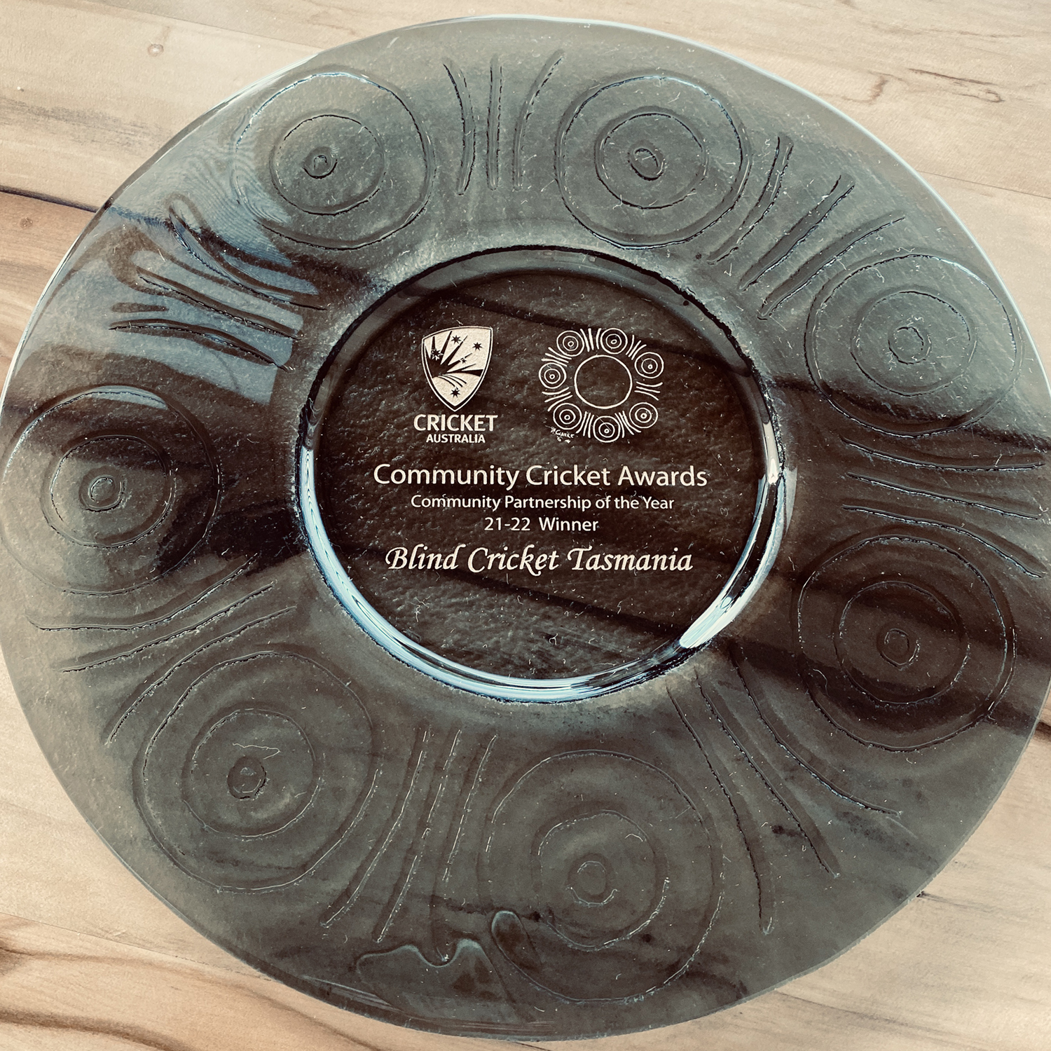 A glass trophy plate given to BCT for winning Cricket Australia's National Community Partnership of the Year Award in 2022