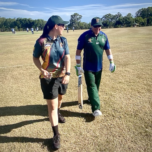 Phil Menzie walking off the field and talking with Coach Taylah Purton after batting agains NSW