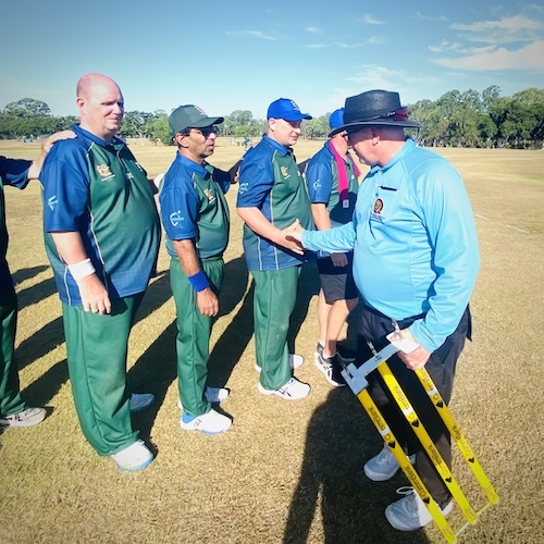 Umpires at the end of a game shake hands with some CATS players