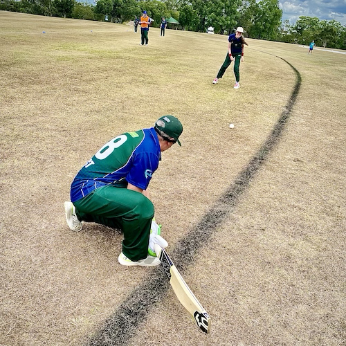 Two TAS CATS players doing pre-game practice on the side of the oval