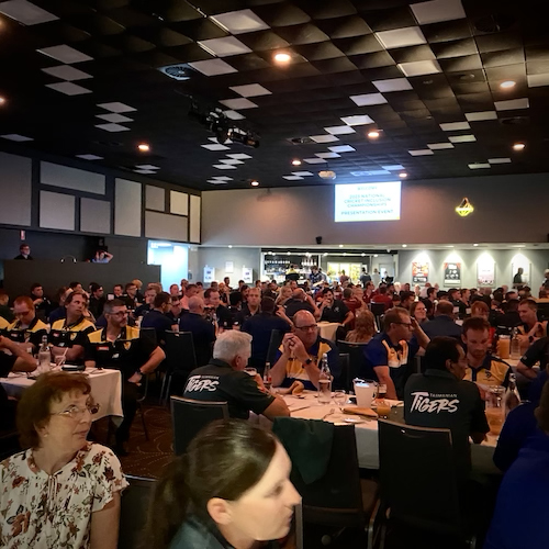 The main room at the NCIC awards presentation night showing hundreds of people in attendance sitting at tables in team groups