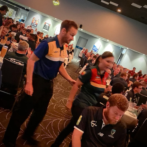 Daniel Searle being assisted to the stage by TAS/ACT CATS Coach Taylah Purton to accept his award for best B1 of the tournament