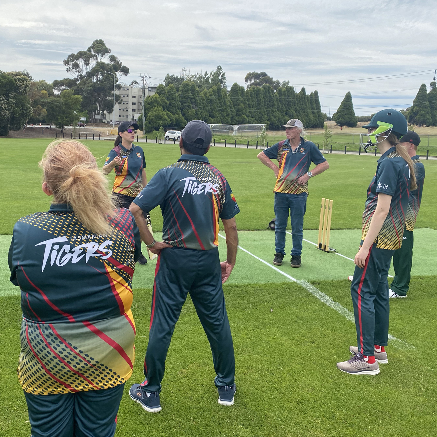Coach Taylah Purton addresses players in the Tigers state team training squad at a local cricket oval as they train for the national championships