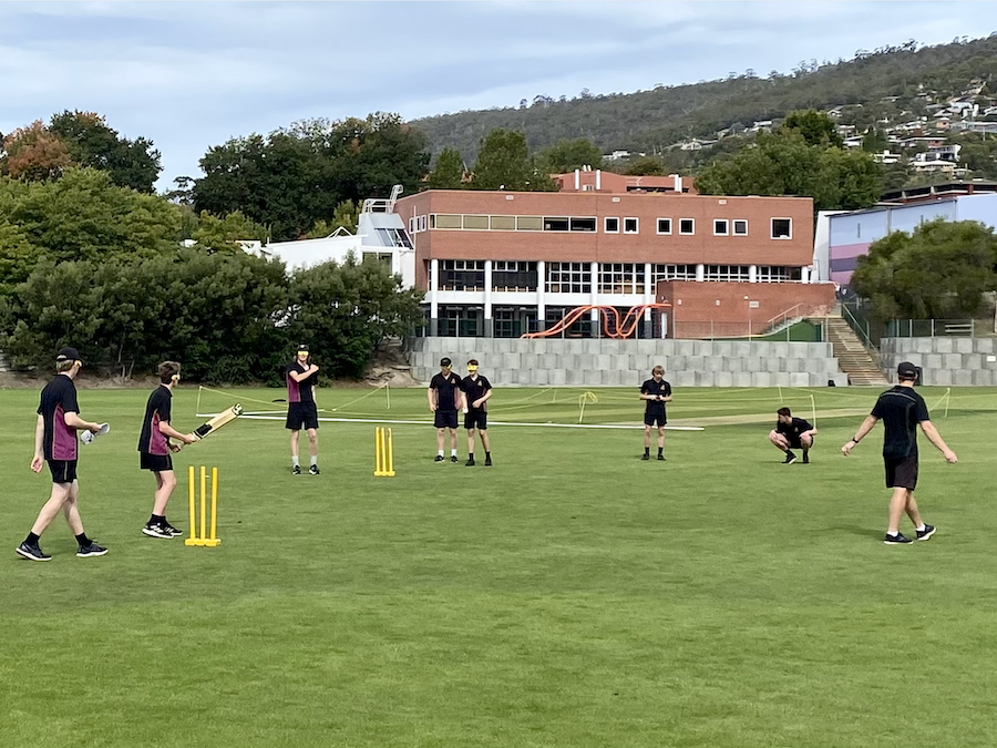 Group shot of Hutchins and Collegiate students playing cricket on the oval together