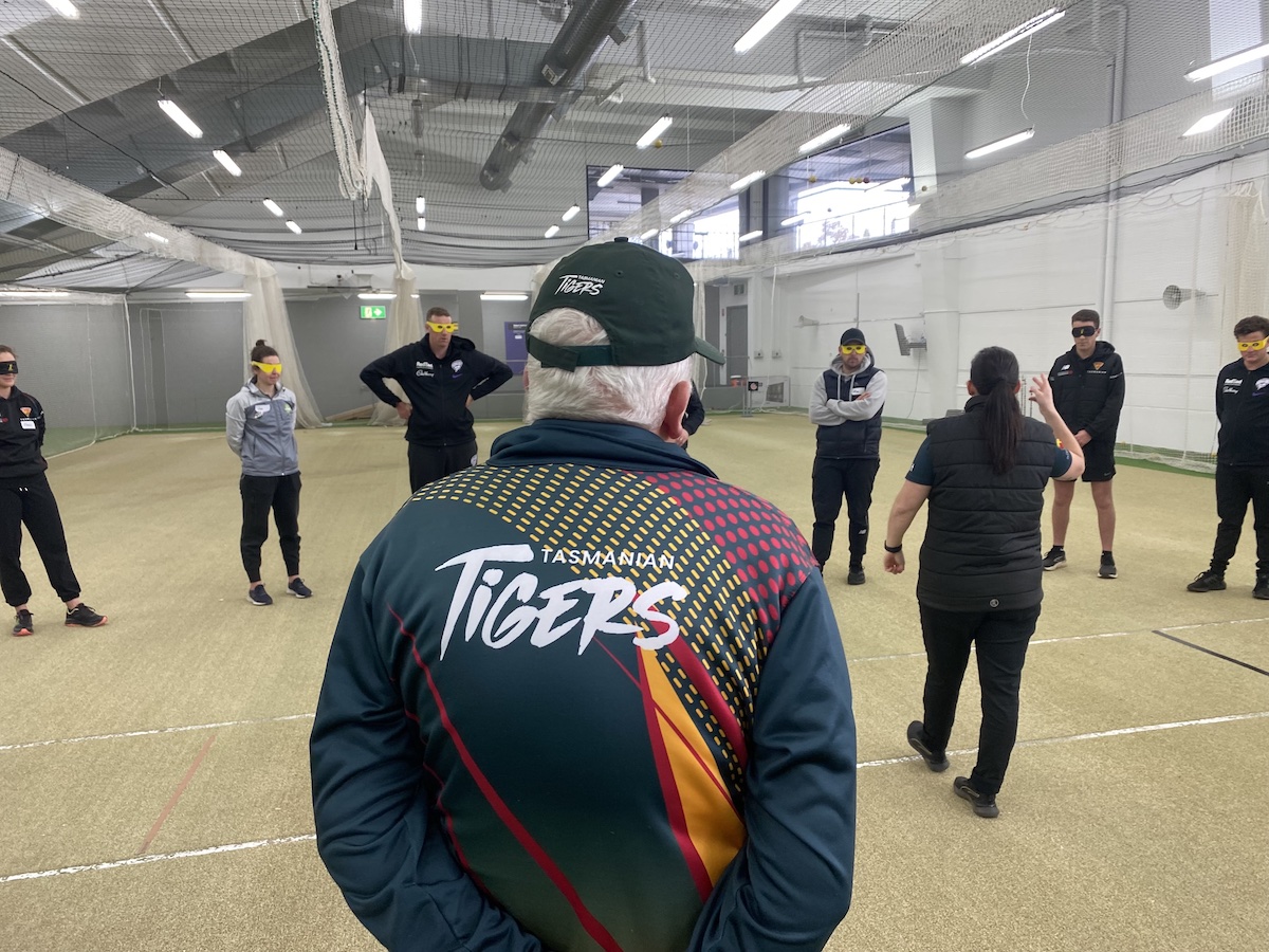 Tas Tiger player teaching Cricket Tasmania staff to play blind cricket