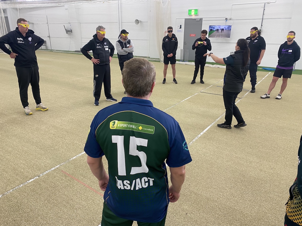 Tas Tiger player and coach teaching Cricket Tasmania staff to play blind cricket