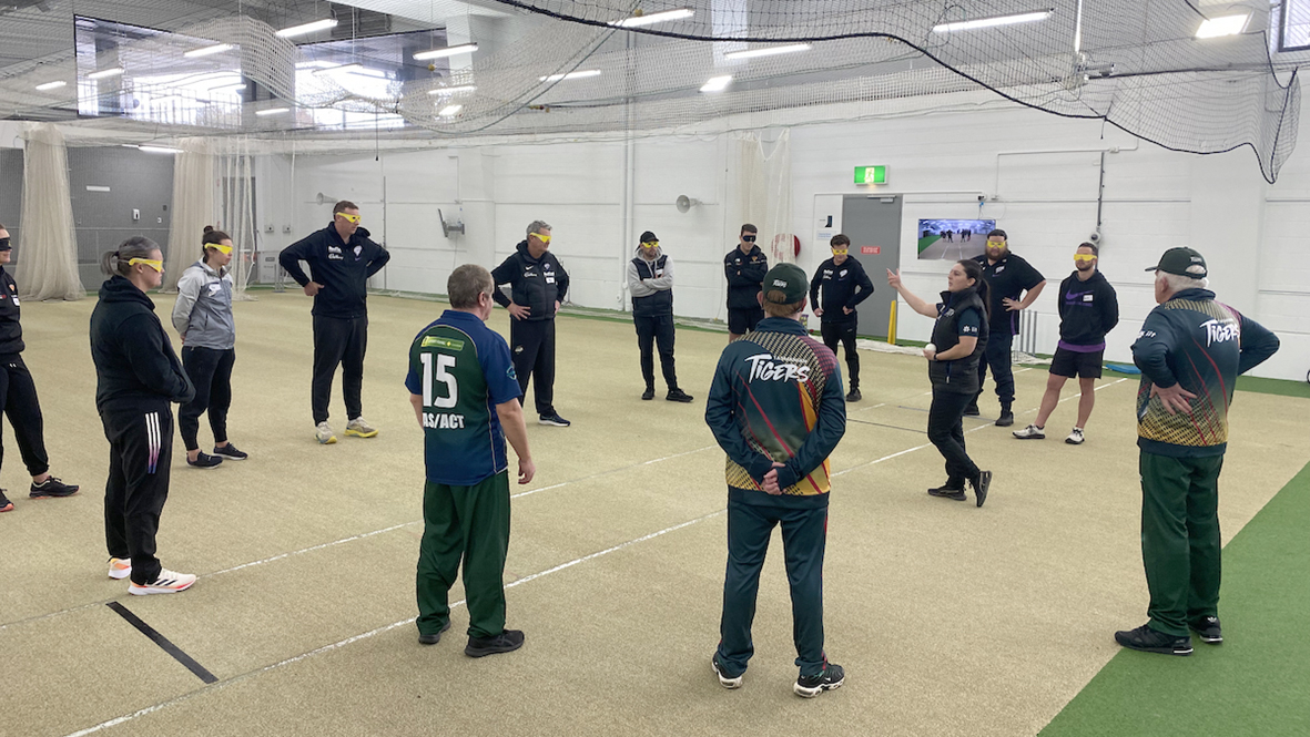 Tas Tiger player and coach teaching Cricket Tasmania staff to play blind cricket